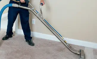 Professional operating a liquid removal machine on a carpeted floor in Baton Rouge, LA